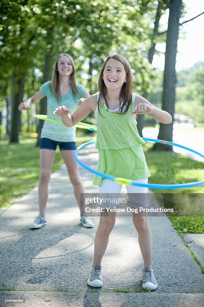 Girls Playing with Hoola Hoops on Sidewalk