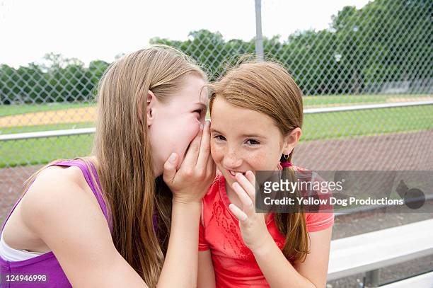 two girls sharing a secret - girl who stands stock pictures, royalty-free photos & images