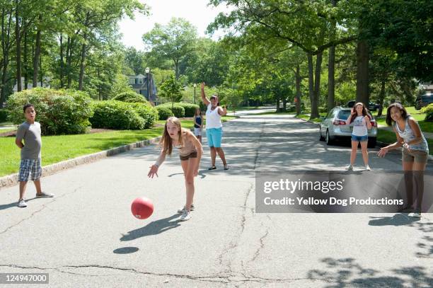 kids playing kickball in a suburban neighborhood - kickball stock pictures, royalty-free photos & images