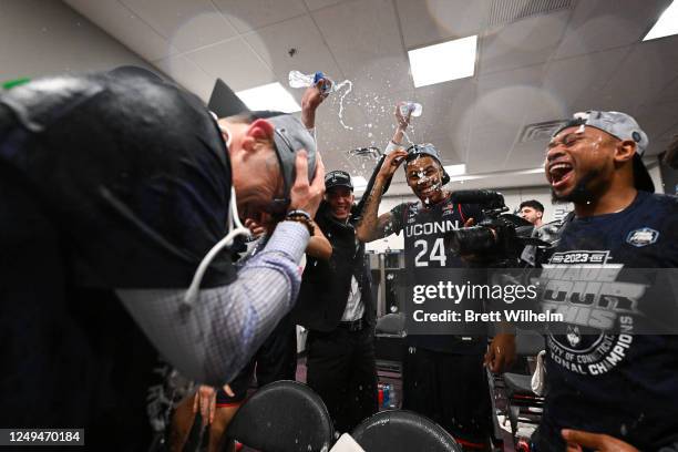 The Connecticut Huskies celebrate their win against the Gonzaga Bulldogs in the locker room during the Elite Eight round of the 2023 NCAA Men's...