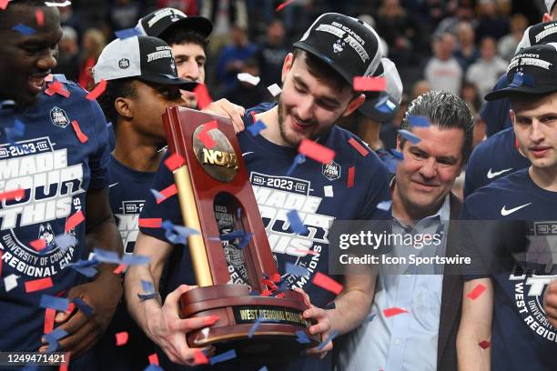 UConn Huskies forward Alex Karaban holds up the trophy after advancing to the Final Four after winning the NCAA Division I Men's Championship Elite...