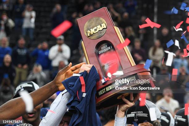 UConn Huskies players hold up the trophy after advancing to the Final Four after winning the NCAA Division I Men's Championship Elite Eight round...