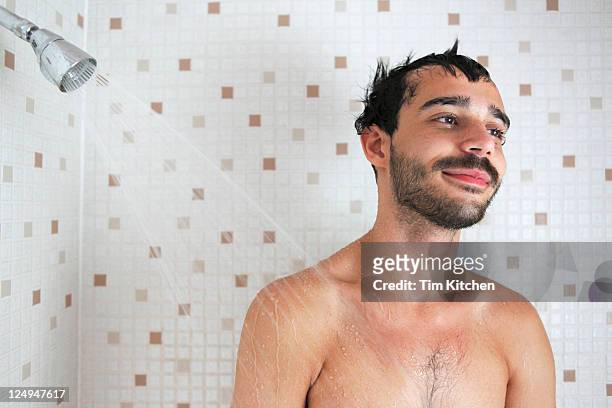 latin guy in shower, smiling - men taking shower stock-fotos und bilder