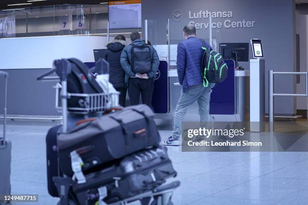 People at a service desk on the first day of a two-day strike by baggage and security staff at Munich Airport on March 26, 2023 near Freising,...