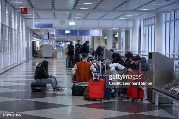 Group of young people waits in the departure hall on the first day of a two-day strike by baggage and security staff at Munich Airport on March 26,...