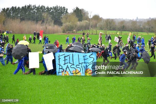 Protesters hold a banner as they head to Sainte-Soline during a demonstration called by the collective "Bassines non merci", the environmental...
