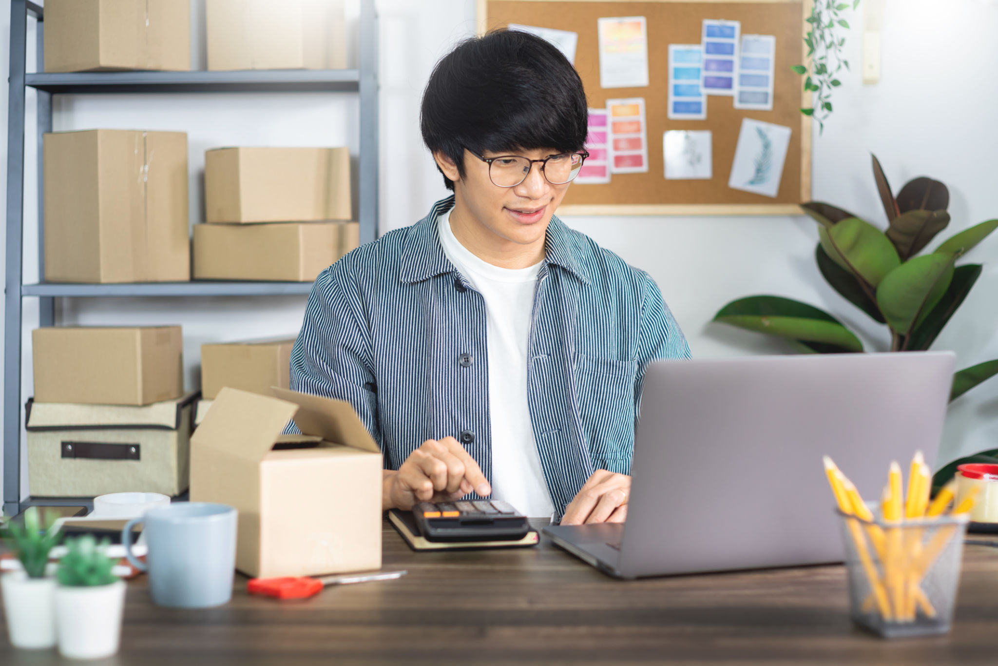 Asian business man startup SME entrepreneur or freelance working in a cardboard box prepares delivery box for customer, Online selling, e-commerce, packaging and shipping concept Asian business man startup SME entrepreneur or freelance working in a cardboard box prepares delivery box for customer, Online selling, e-commerce, packaging and shipping concept