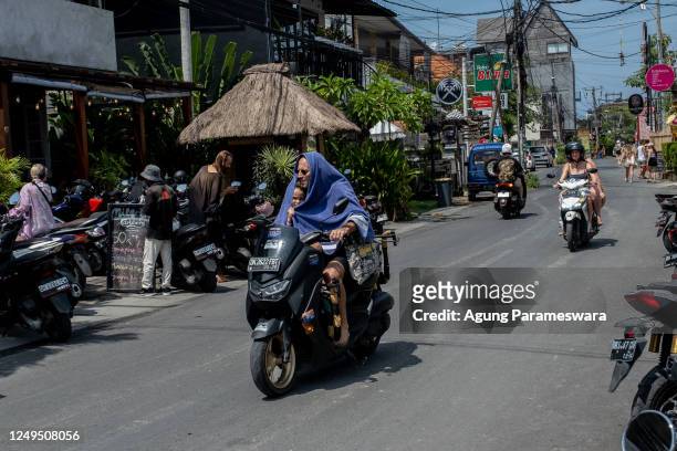 Tourists ride motorcycle without helmet at a main road on March 26, 2023 in Canggu, Bali, Indonesia. Indonesian island of the gods plans to enact...