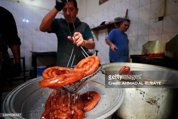 Confectioners prepare traditional sweets during the Muslim holy fasting month of Ramadan in the Sadria district of central Baghdad, on March 26, 2023.