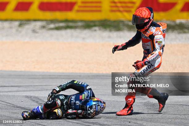 Honda Spanish rider Marc Marquez checks on Aprilia Portuguese rider Miguel Oliveira after crashing during the MotoGP race of the Portuguese Grand...