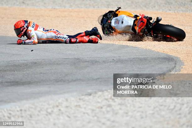 Honda Spanish rider Marc Marquez falls after crashing with Aprilia Portuguese rider Miguel Oliveira during the MotoGP race of the Portuguese Grand...