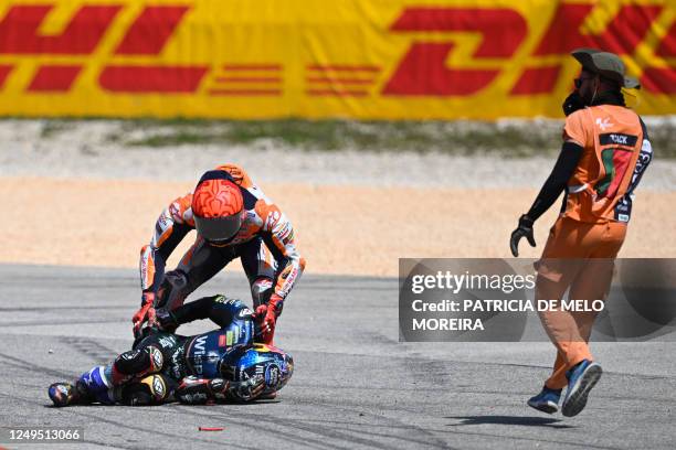 Honda Spanish rider Marc Marquez checks on Aprilia Portuguese rider Miguel Oliveira after crashing during the MotoGP race of the Portuguese Grand...