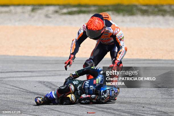 Honda Spanish rider Marc Marquez checks on Aprilia Portuguese rider Miguel Oliveira after crashing during the MotoGP race of the Portuguese Grand...