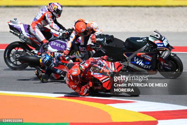 Honda Spanish rider Marc Marquez crashes with Aprilia Portuguese rider Miguel Oliveira as Ducati Italian rider Francesco Bagnaia rides past during...
