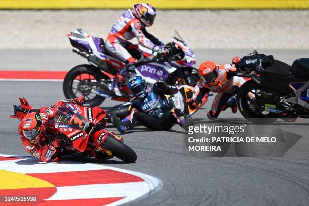 Honda Spanish rider Marc Marquez crashes with Aprilia Portuguese rider Miguel Oliveira as Ducati Italian rider Francesco Bagnaia rides past during...