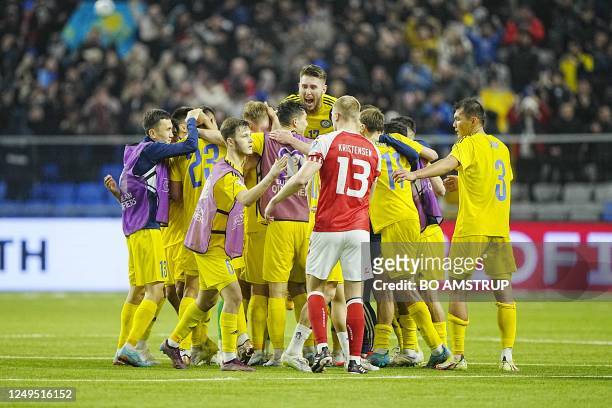 Players from Kasakhstan celebrates after winning the UEFA Euro 2024 Group H qualification football match Kasakhstan v Denmark next to Denmark's...