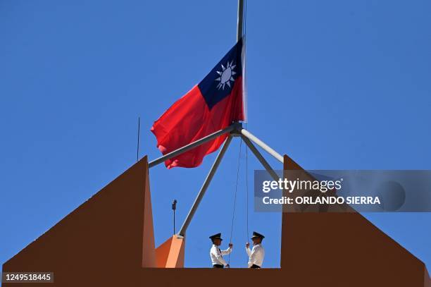 Taiwan's marine corps personnel lower Taiwan's national flag from the roof of Taiwan's Embassy in Tegucigalpa on March 26, 2023. - China and Honduras...