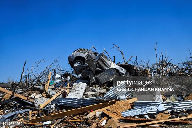 Car sits on top of a damaged house in Rolling Fork, Mississippi, after a tornado touched down in the area, on March 26, 2023. - Mississippi started...