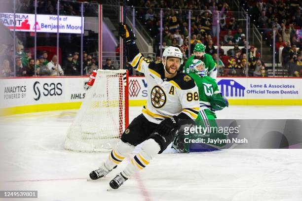 David Pastrnak of the Boston Bruins scores a goal and celebrates during the first period of the game against the Carolina Hurricanes at PNC Arena on...