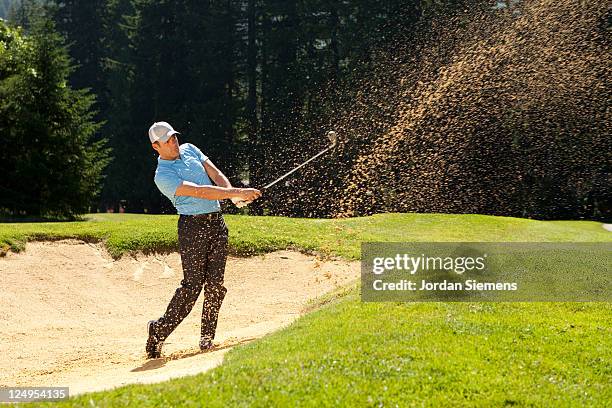 a man hitting out of a sand trap. - golfspelare bildbanksfoton och bilder