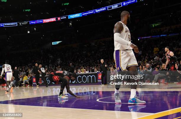 Patrick Beverley of the Chicago Bulls touches the Los Angeles Lakers basketball court as he celebrates after scoring a basket against LeBron James of...