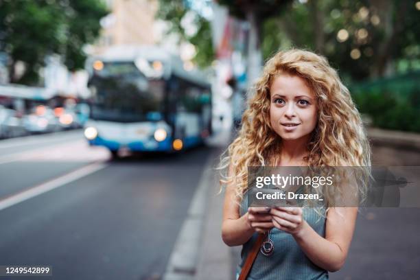 millennial woman using mobile app for ride sharing or public transportation - sydney bus stock pictures, royalty-free photos & images