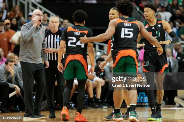 Miami Hurricanes head coach Jim Larranaga, left, talks to his team during a break in play against the Texas Longhorns in the Elite Eight round of the...