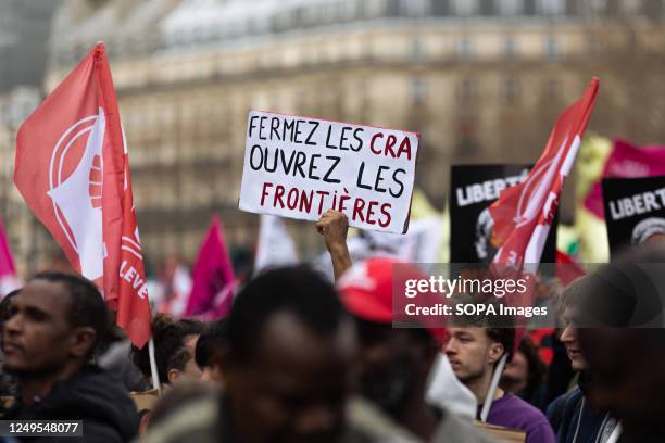 Protester holds a placard that says " Fermez les CRA Ouvrez les frontières" during a demonstration against Darmanin's law. Thousands of French and...