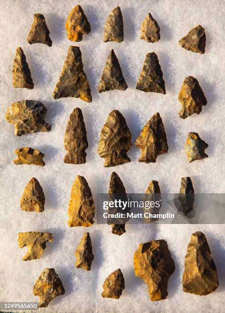 ancient native american arrowheads on white background - punta di freccia foto e immagini stock