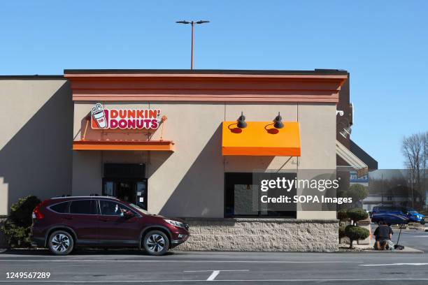 Customer picks up an order at the Dunkin' Donuts drive-thru window.