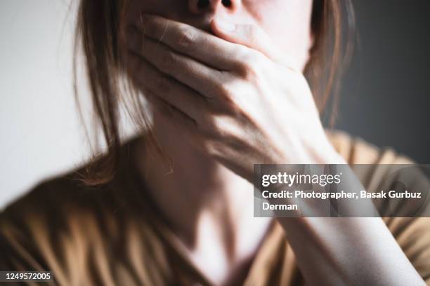 a woman covering her mouth with her hand - censorship imagens e fotografias de stock