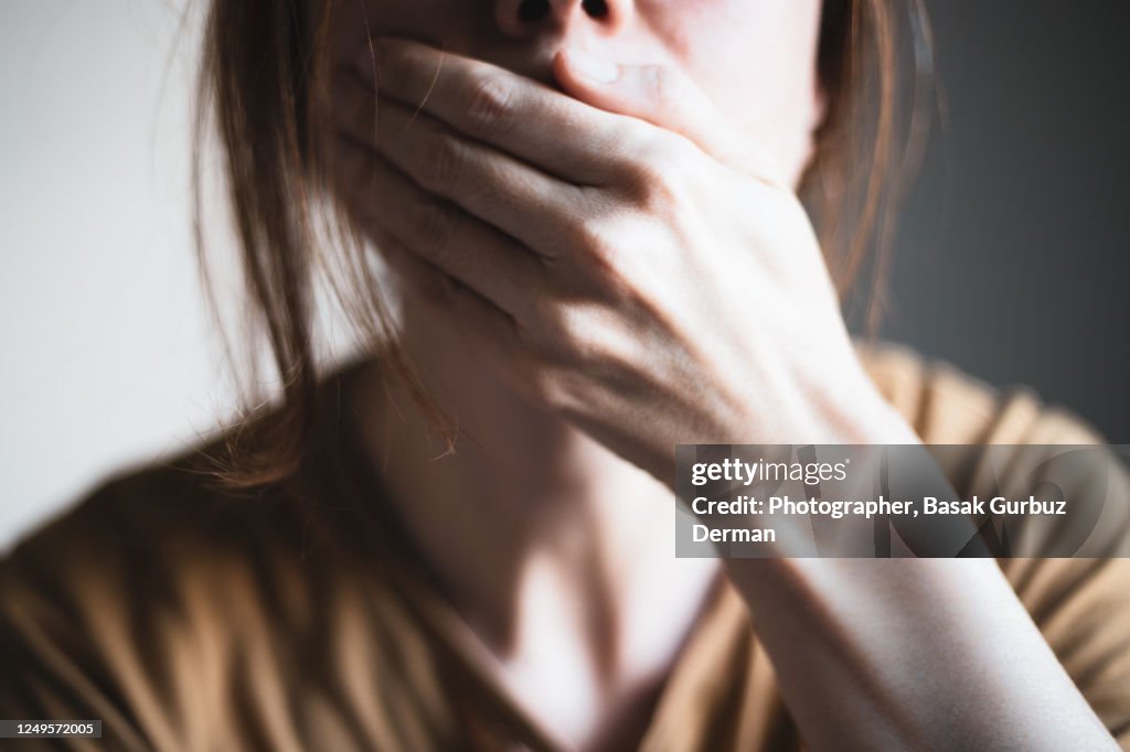 A woman covering her mouth with her hand