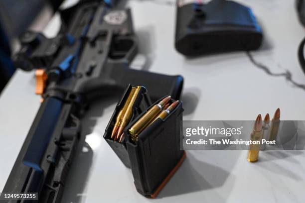 An AR-15 style weapon, a magazine with bullets and different style of bullets are displayed on a table at the home of Rob Pincus on September 23,...