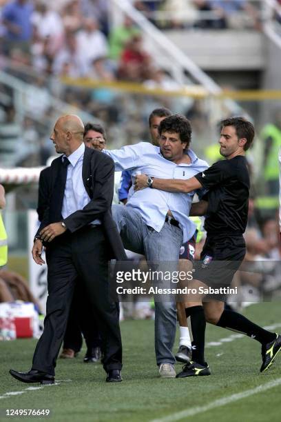 Referee Alberto Rizzoli holds Silvio Baldini head coach of Parma Calcio while kicking Domenico Di Carlo head coach of Catania Calcio during the Serie...