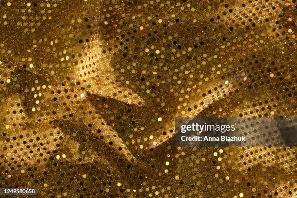 glowing shiny golden textile. fabric with gold sequins. festive background. - lap dancing stockfoto's en -beelden