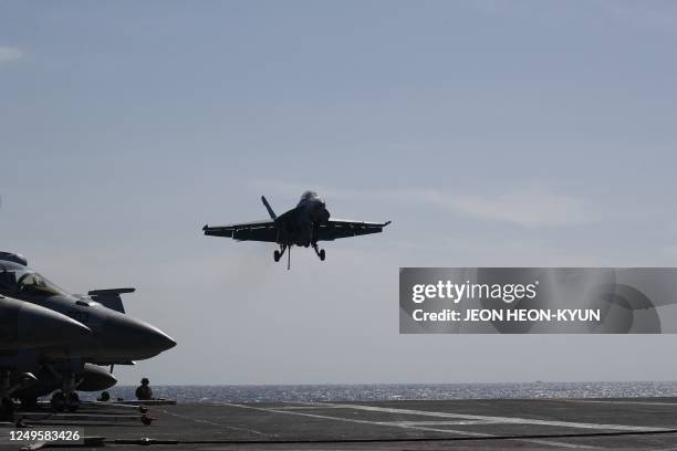 Navy F-18 Super Hornet lands on the flight deck on the USS Nimitz, off the coast of Busan on March 27, 2023. - The South Korean and US military...