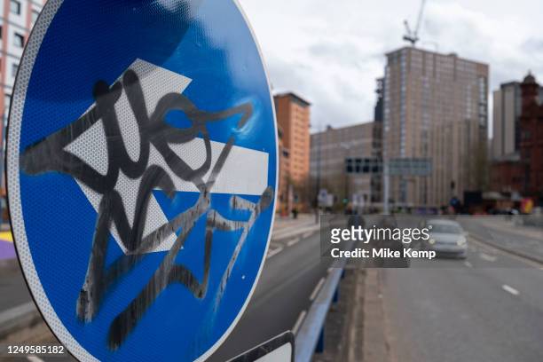 Vehicles passing a graffiti covered one way sign on the James Watt Queensway dual carriageway in the city centre on 22nd March 2023 in Birmingham,...