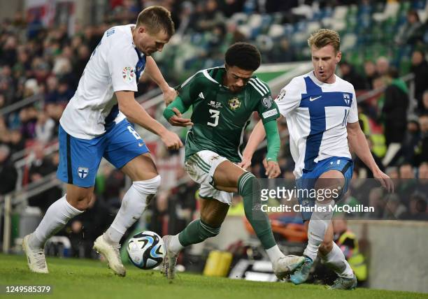 Jamal Lewis of Northern Ireland is tackled by Robin Lod and Rasmus Schuller of Finland during the UEFA EURO 2024 qualifying round group B match...