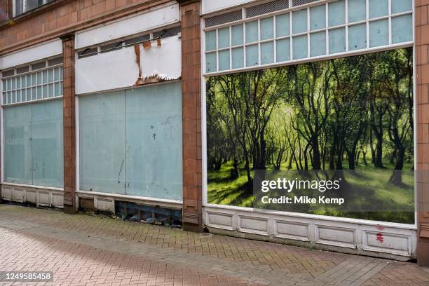 Beautiful image of trees in nature painted in a picture of a woodland in an empty retail space window on 22nd March 2023 in Birmingham, United...