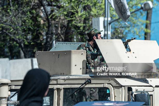 Taliban security personnel sits on a humvee armored vehicle near the site of a suicide attack in Kabul on March 27, 2023. - A suicide attack on March...