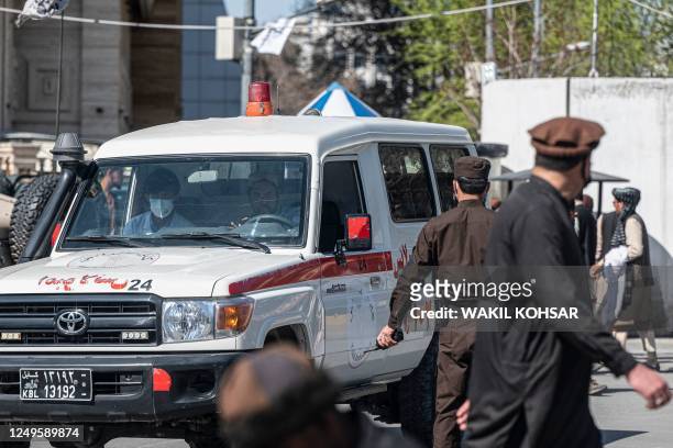An ambulance carries victims from near the site of a suicide attack in Kabul on March 27, 2023. - A suicide attack on March 27 not far from...