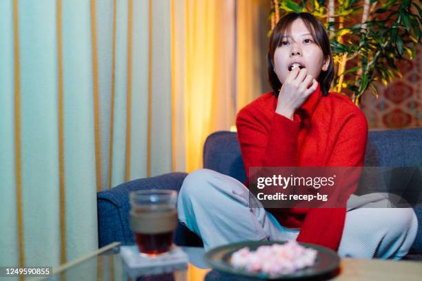 young woman watching movie at home at night - home movie stock pictures, royalty-free photos & images