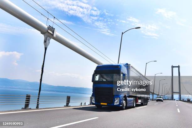 truck passing through the bridge - semi truck headlight stock pictures, royalty-free photos & images