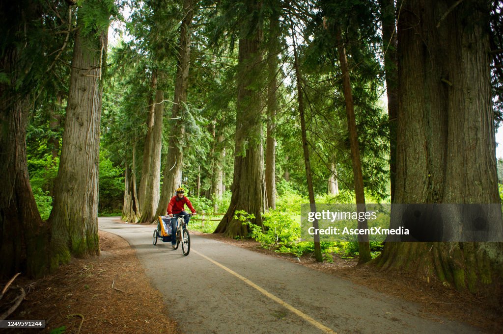 Homem pedalando uma trilha panorâmica com seu filho