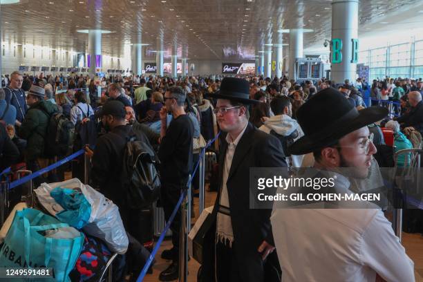 Passengers wait for their flights during a strike at departures hall in Ben Gurion International airport near Tel Aviv, on March 27, 2023. - The...
