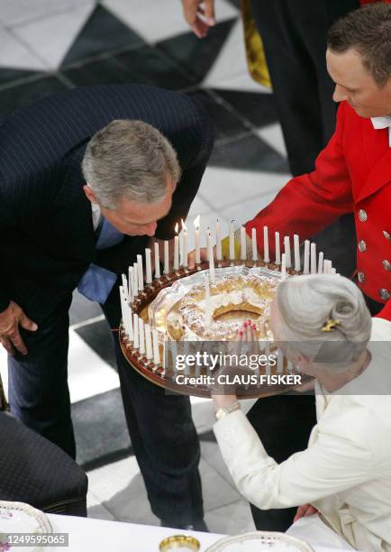 President Bush blows out all the candles on his birthday cake, presented to him by Denmark´s Queen Margrethe , at the Fredensborg Palace in...