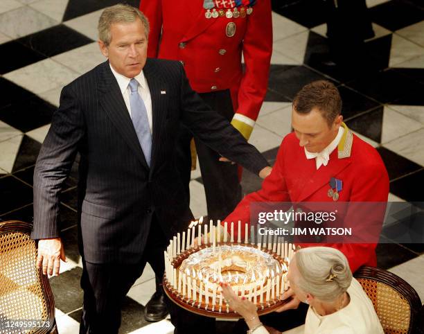 President George W. Bush gets ready to blow his birthday candles on a cake presented to him by Queen Margrethe II of Denmark 06 July 2005 during a...