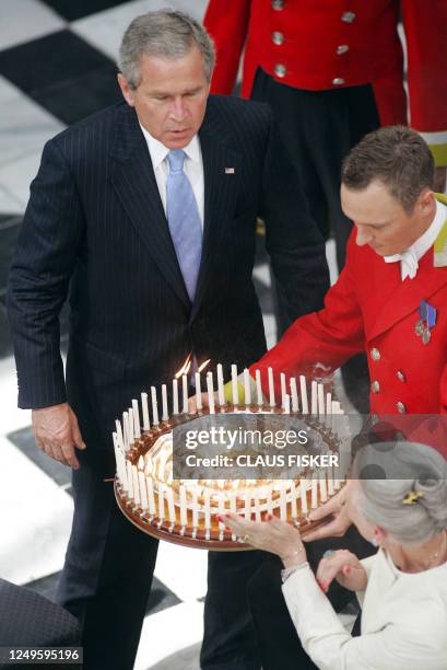 President Bush is about to blow out all the candles on his birthday cake, presented to him by Denmark´s Queen Margrethe , at the Fredensborg Palace...