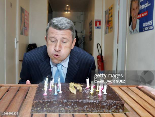 French far-right presidential candidate Philippe de Villiers blows candles as he attends his birthday party at his campaign headquarters, 25 March...