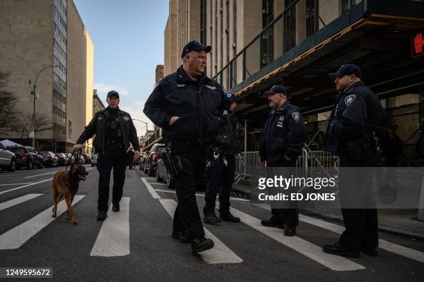 Police officers walk outside the Criminal Court building and DA's office in New York on March 27, 2023 - Donald Trump staged his first presidential...